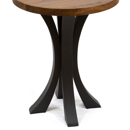 Small round table with wooden top and black curved legs on a white background