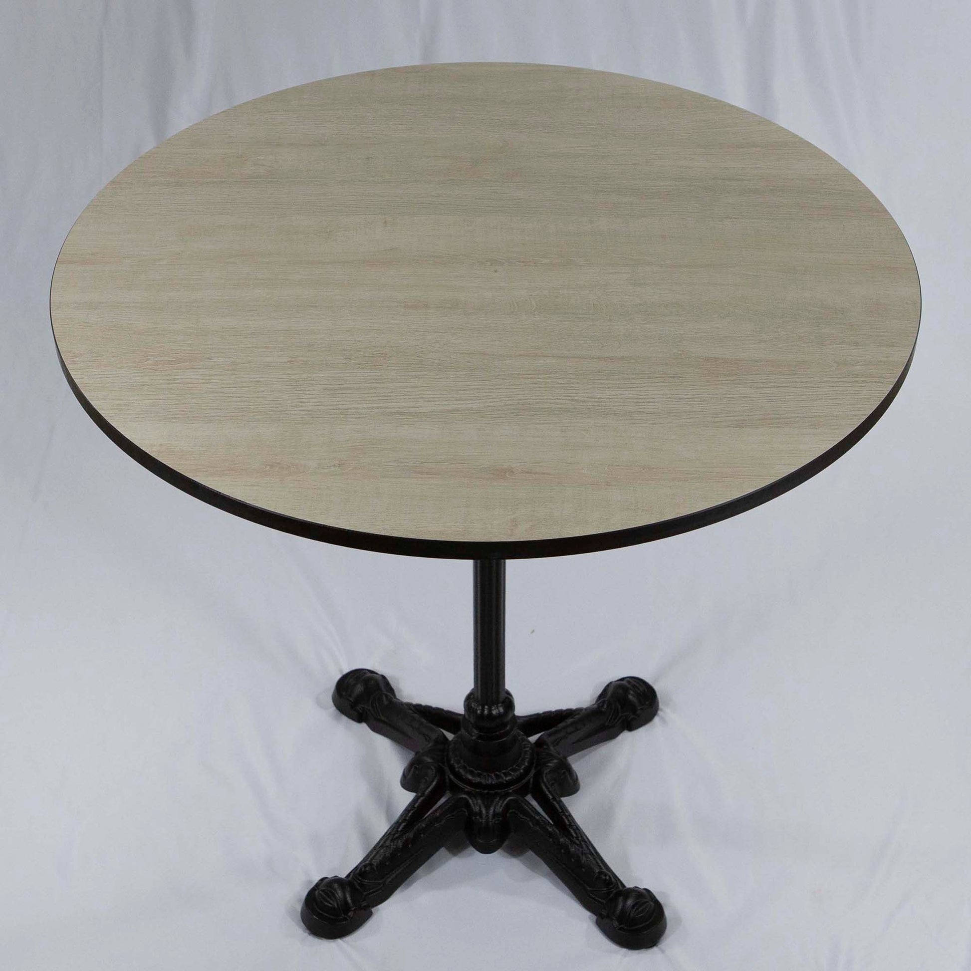 Round table with a light wooden top and black metal base on a white background