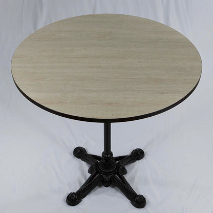 Round table with a light wooden top and black metal base on a white background
